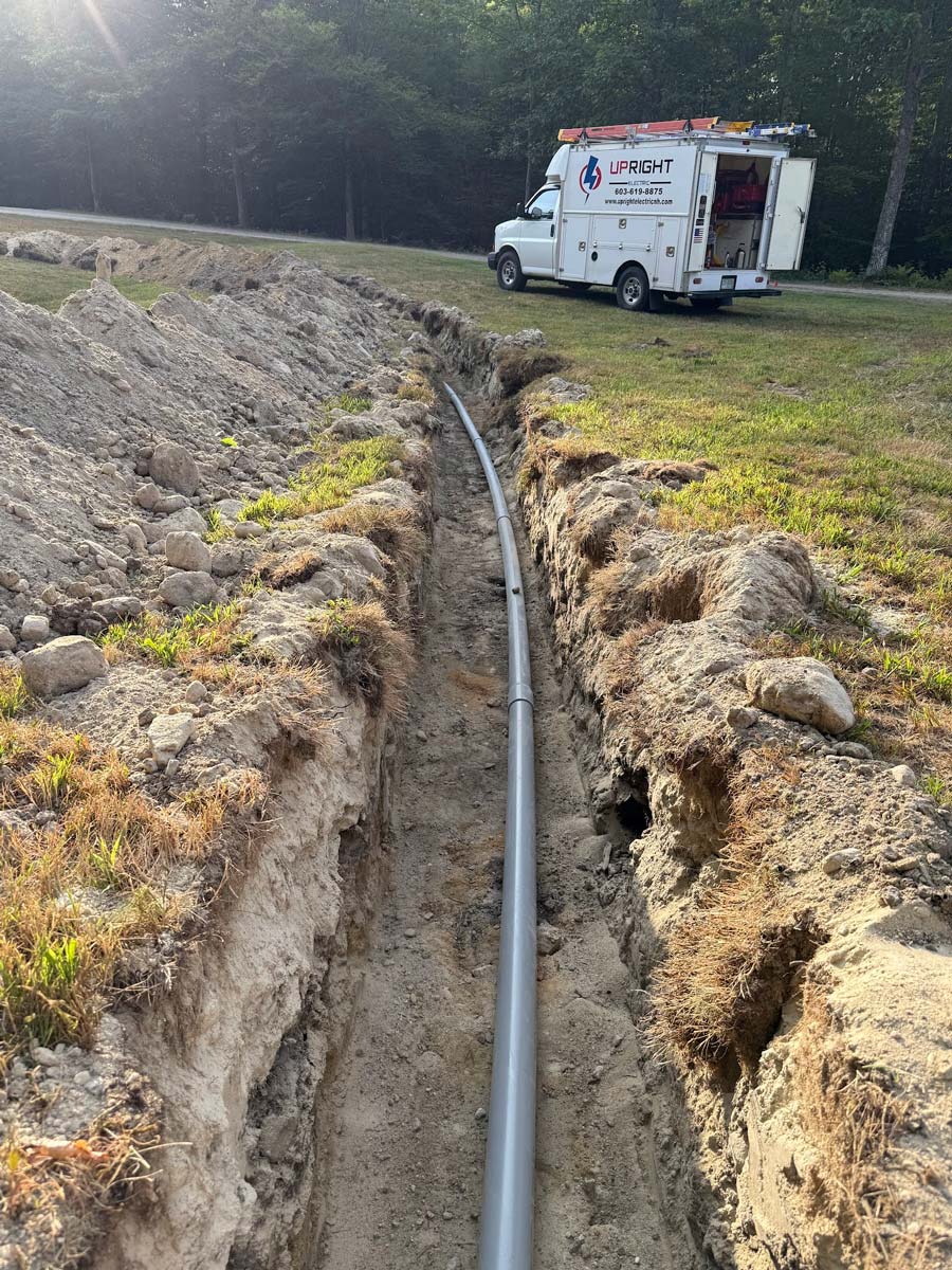 Upright Electric van beside a trench with PVC conduit for an underground commercial run