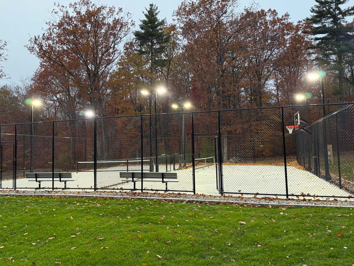 Pole-mounted LED floodlights lighting an outdoor sports court in Wolfeboro, New Hampshire