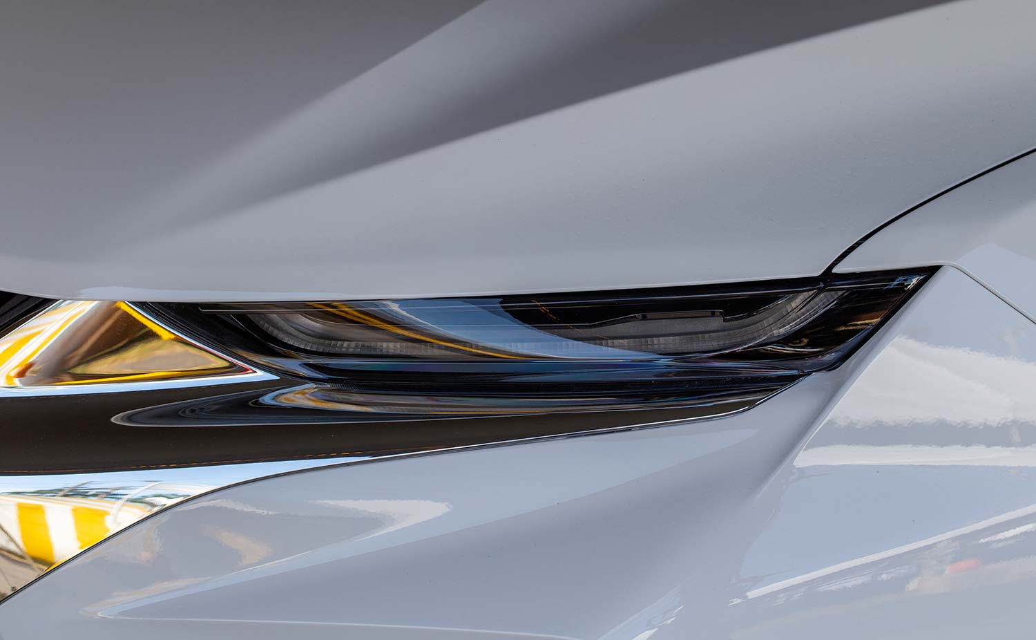 Close-up of a white electric vehicle headlight and front fender