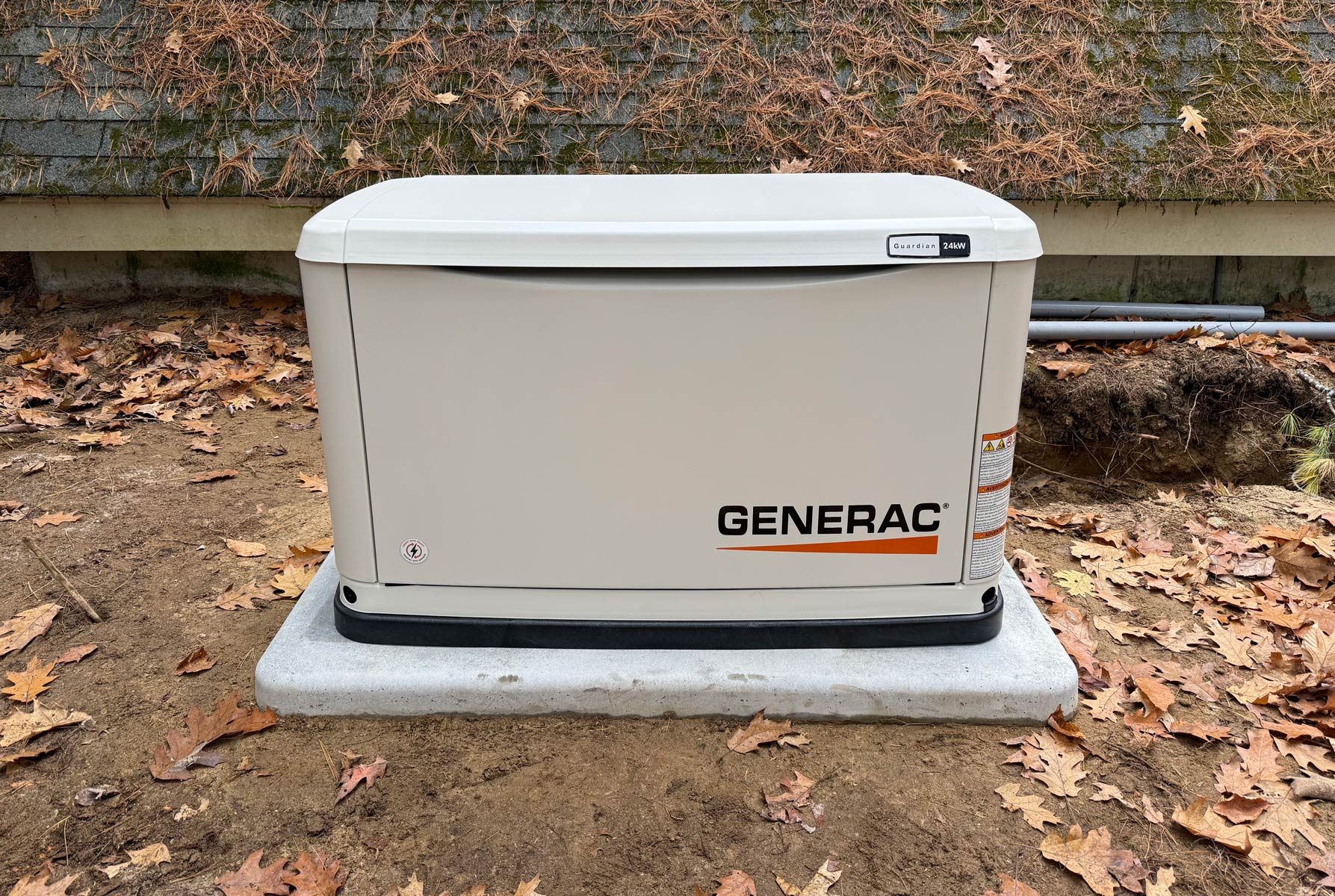 Generac Guardian 24kW standby generator installed on a concrete pad beside a New Hampshire home