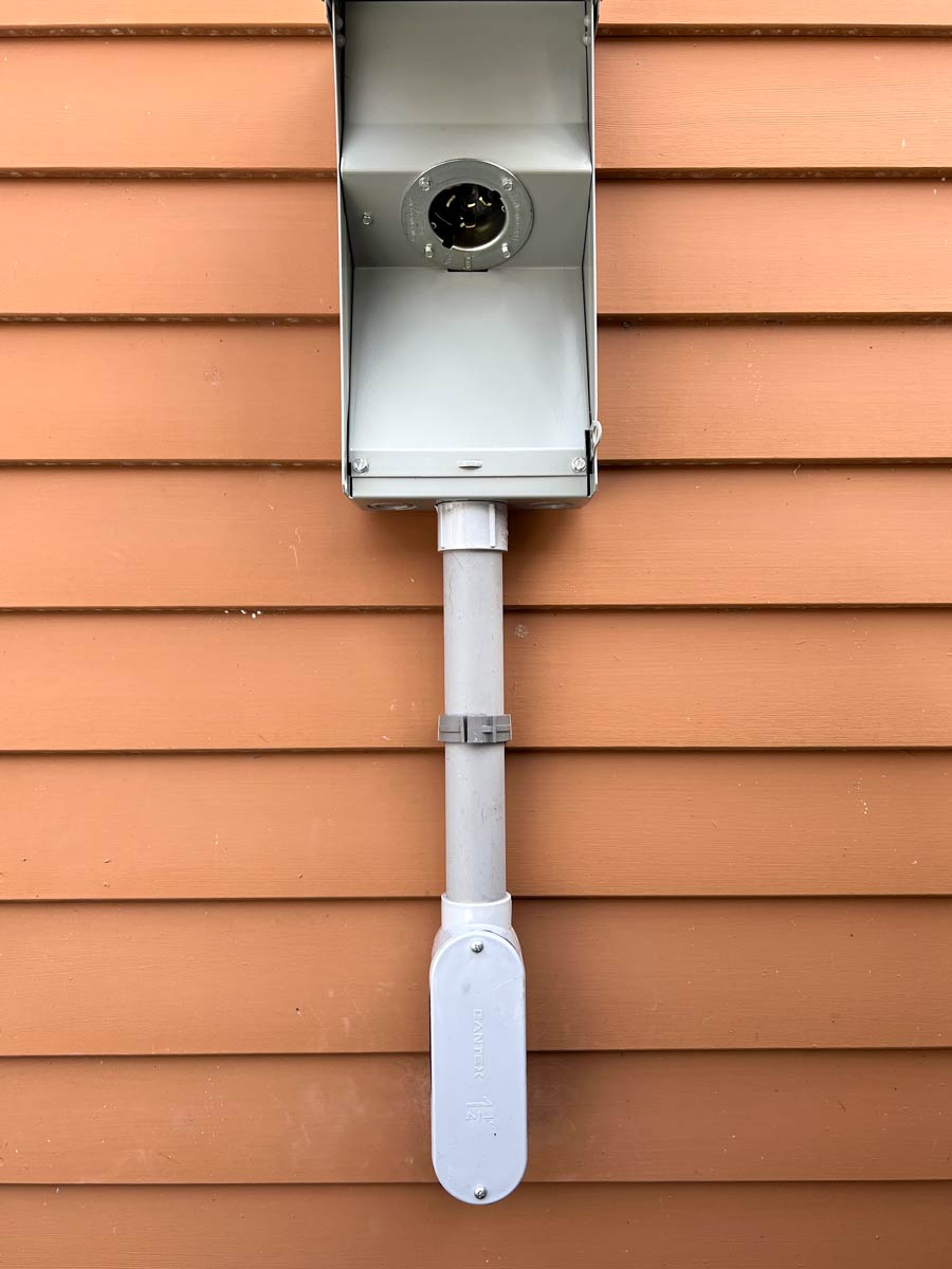 Weatherproof 50-amp generator inlet and conduit on a Lakes Region home