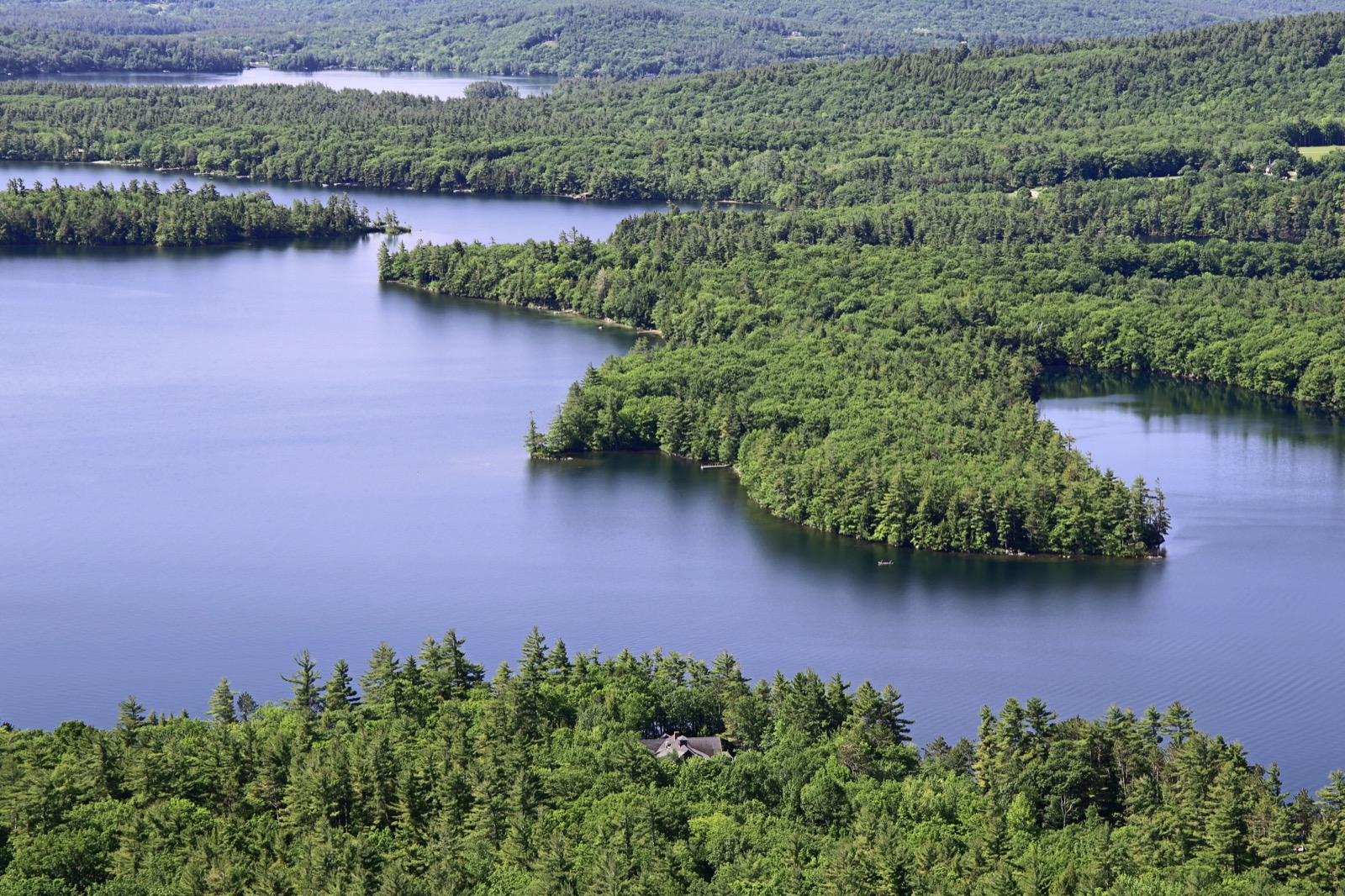 Aerial view of wooded lakefront homes along a lake in New Hampshire's Lakes Region
